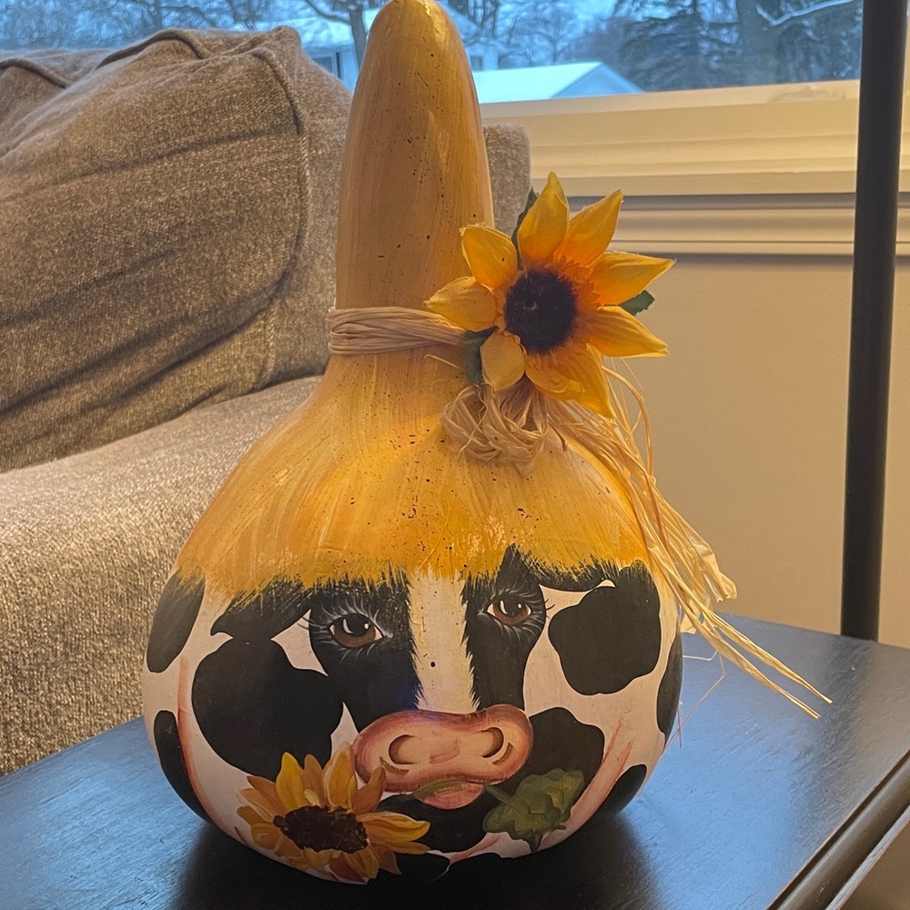 Hand painted gourd decorated with a cow design and sunflowers